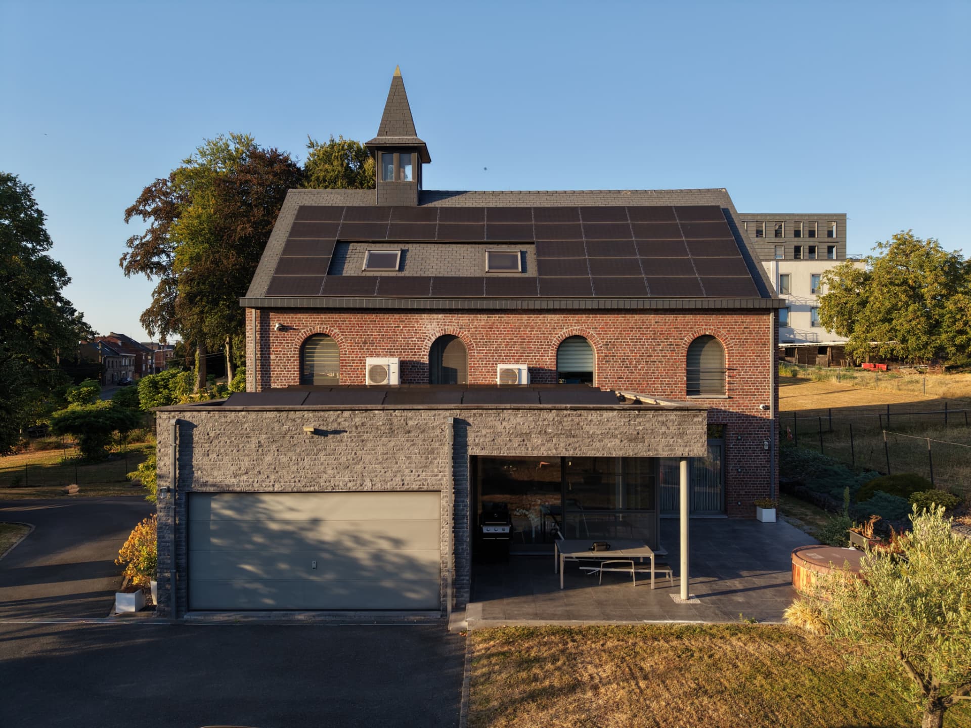 Vue arrière de l'habitation avec l'extension contemporaine et sa grande porte vitrée