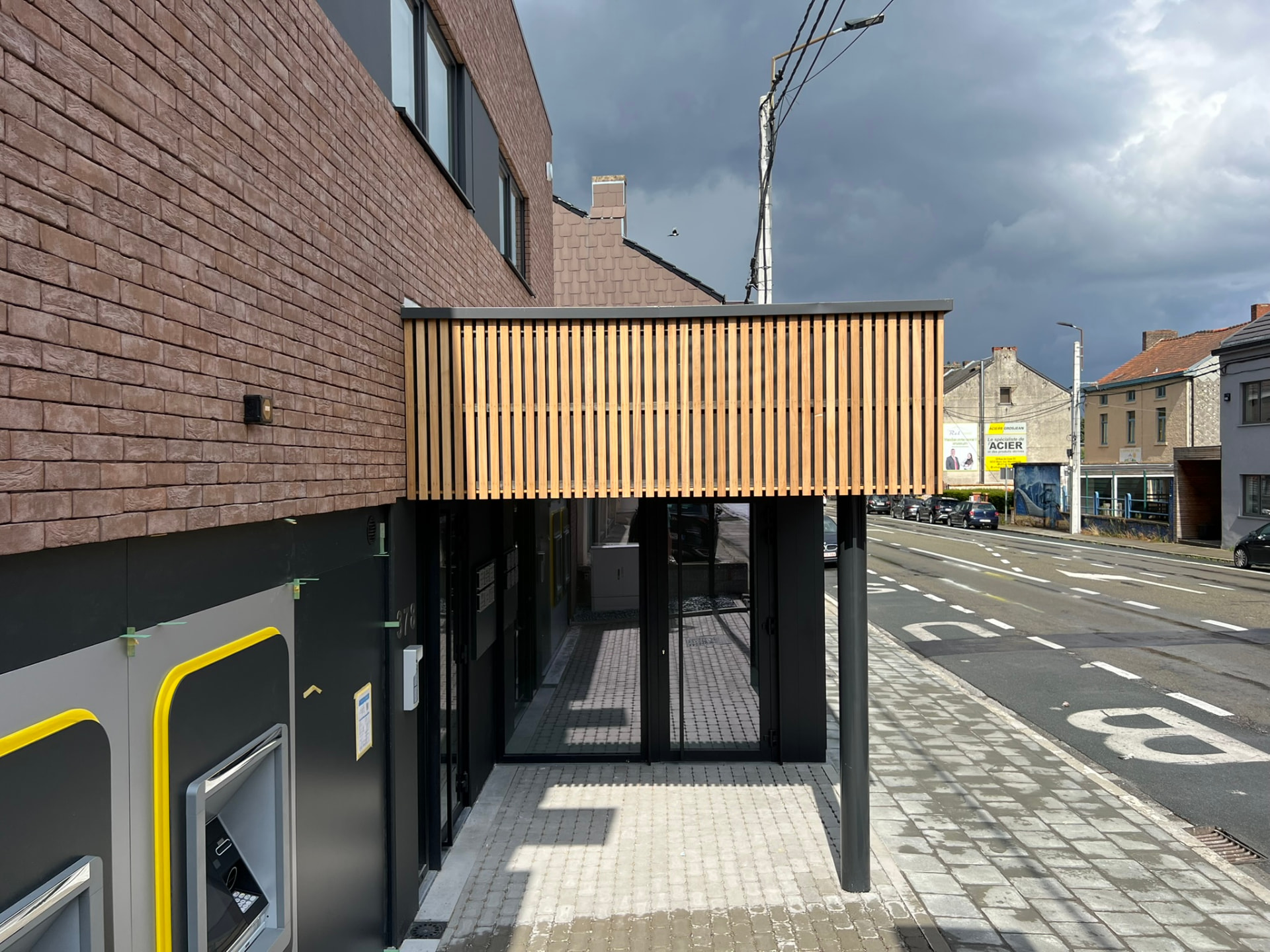 Auvent en lattes de bois en porte-à-faux au-dessus de l'entrée du passage