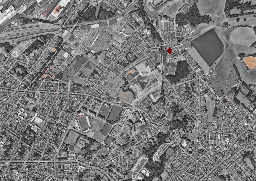 Vue aérienne en noir et blanc de Manage avec le repère rouge de l'implantation du projet