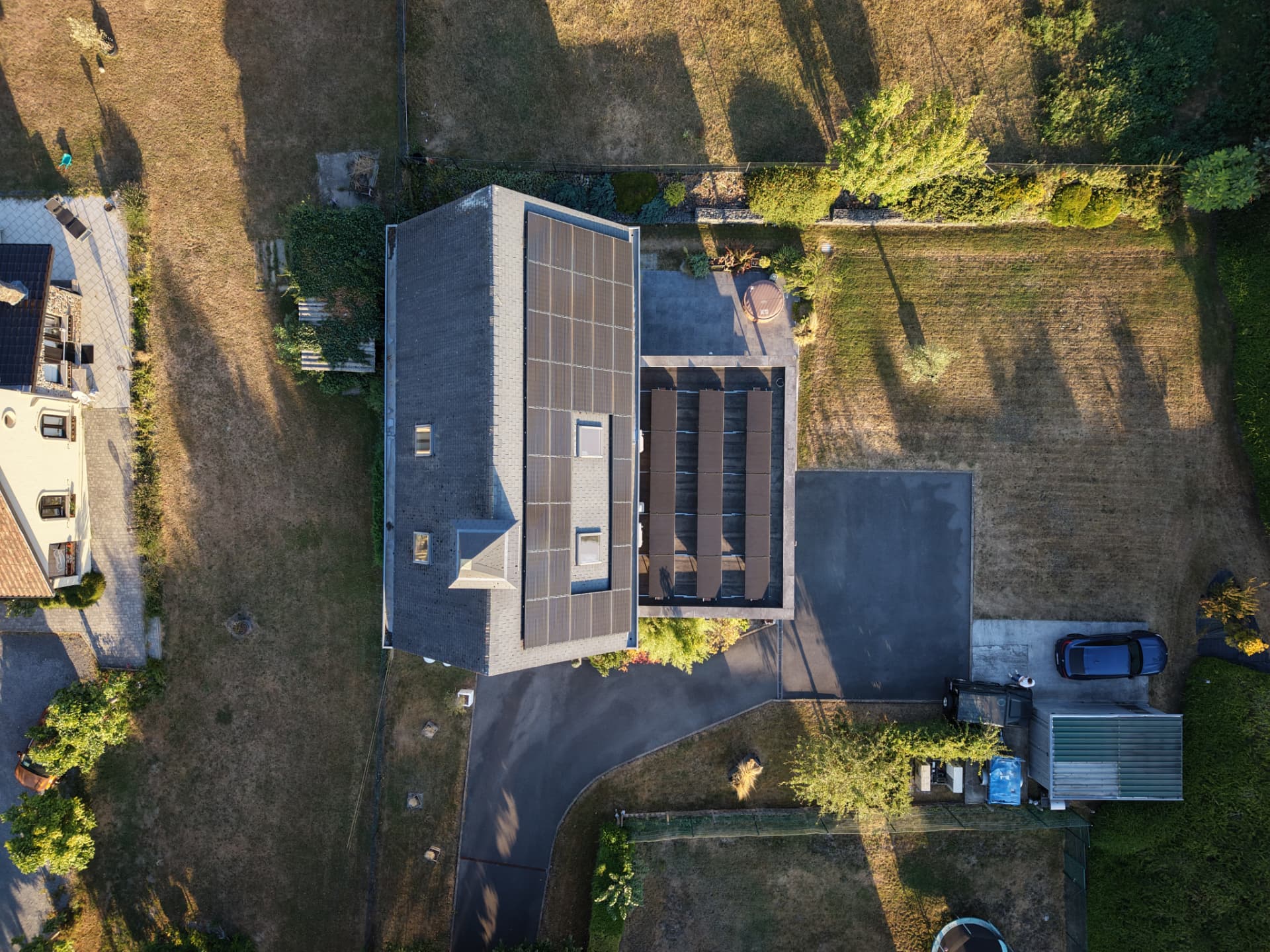 Vue aérienne zénithale de l'habitation, de sa toiture solaire et du jardin