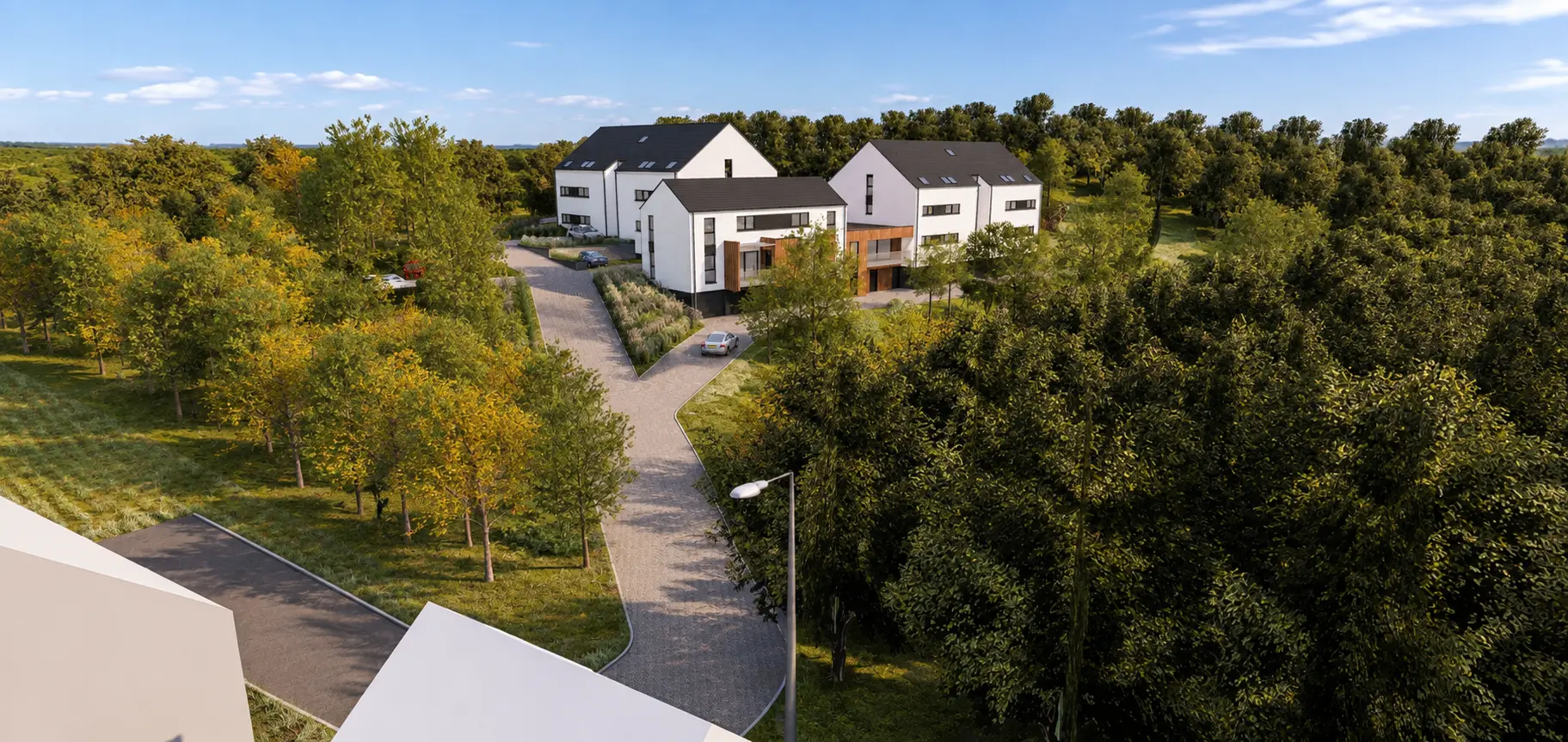 Vue aérienne des volumes blancs à pignons du projet de logements groupés Clos des Etangs à Manage