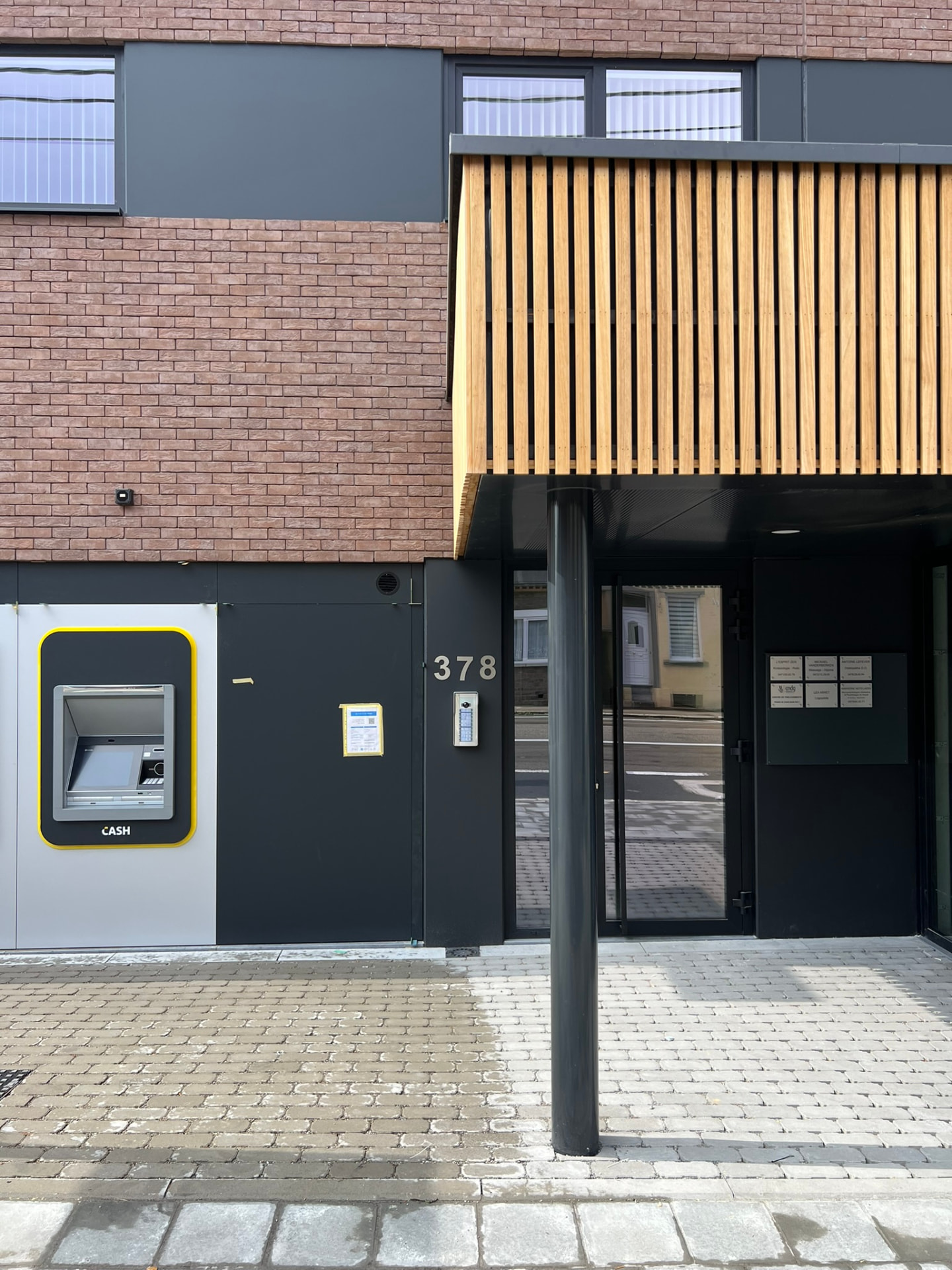 Entrée des logements au numéro 378 avec bardage bois et menuiseries noires