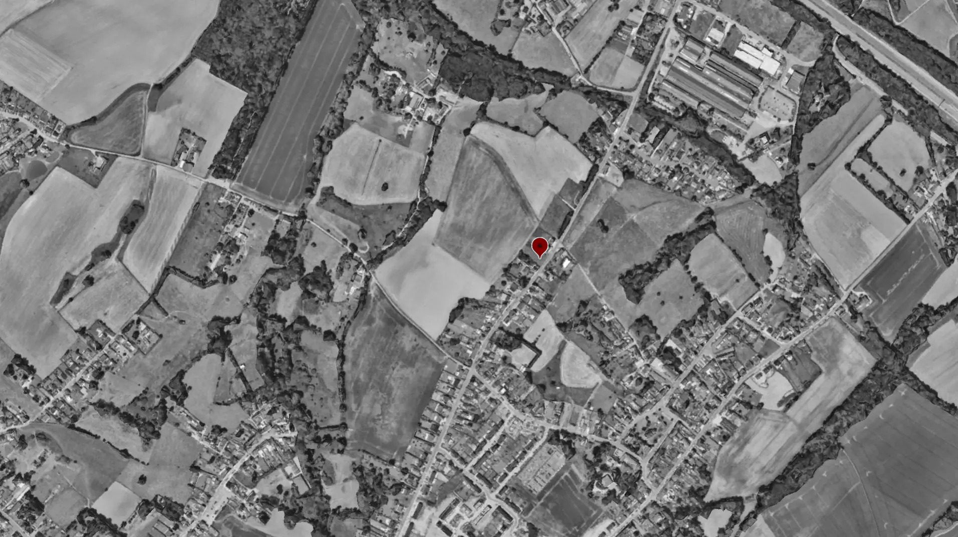 Vue aérienne en noir et blanc de Manage avec le repère rouge de l'implantation du projet