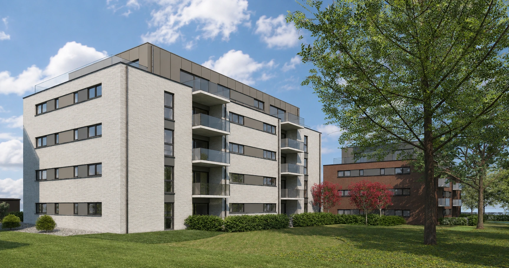 Immeuble d'appartements en briques claires avec balcons vitrés, vue depuis la pelouse