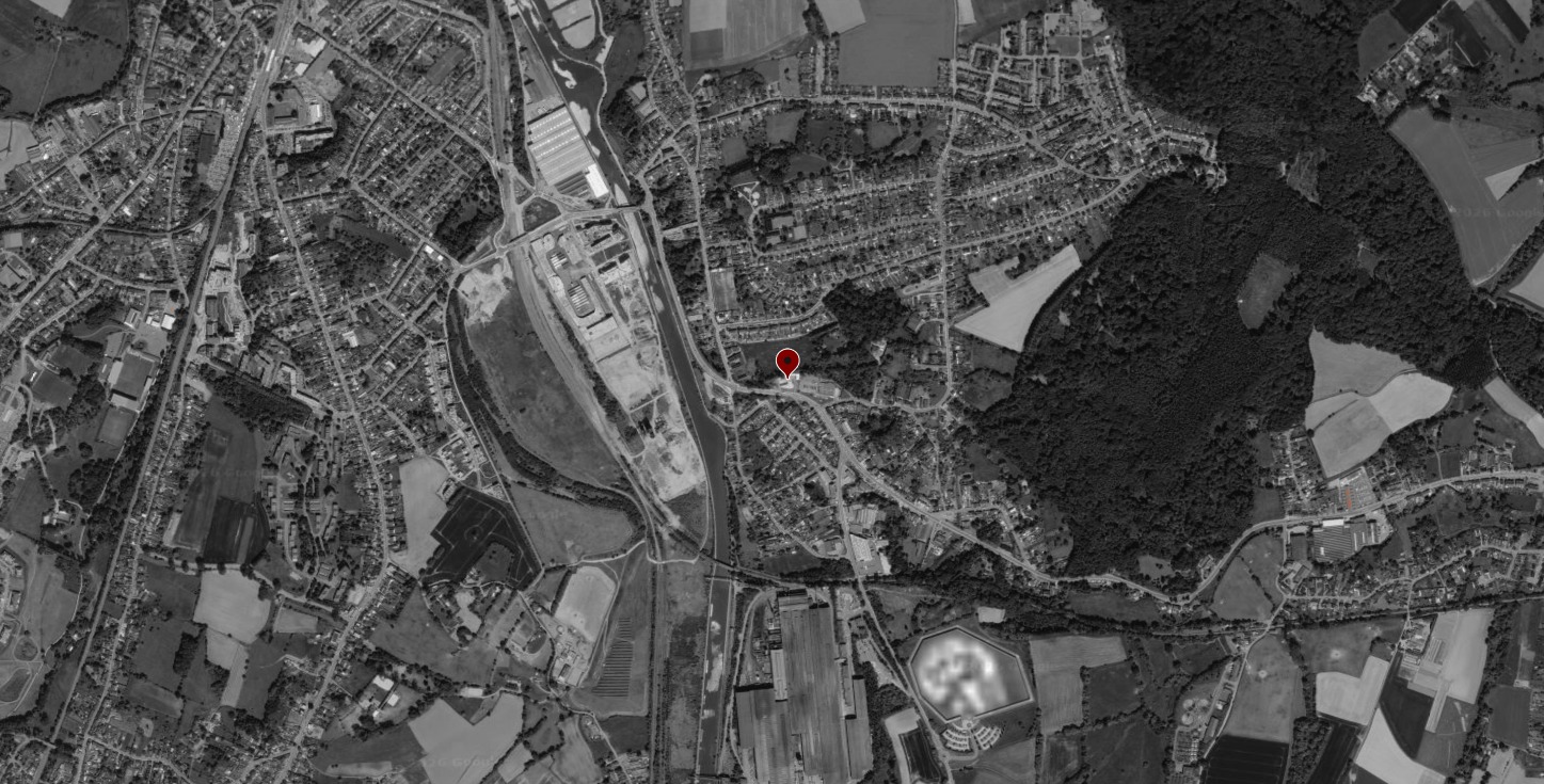 Vue aérienne en noir et blanc de Tubize avec le repère rouge de l'implantation du projet