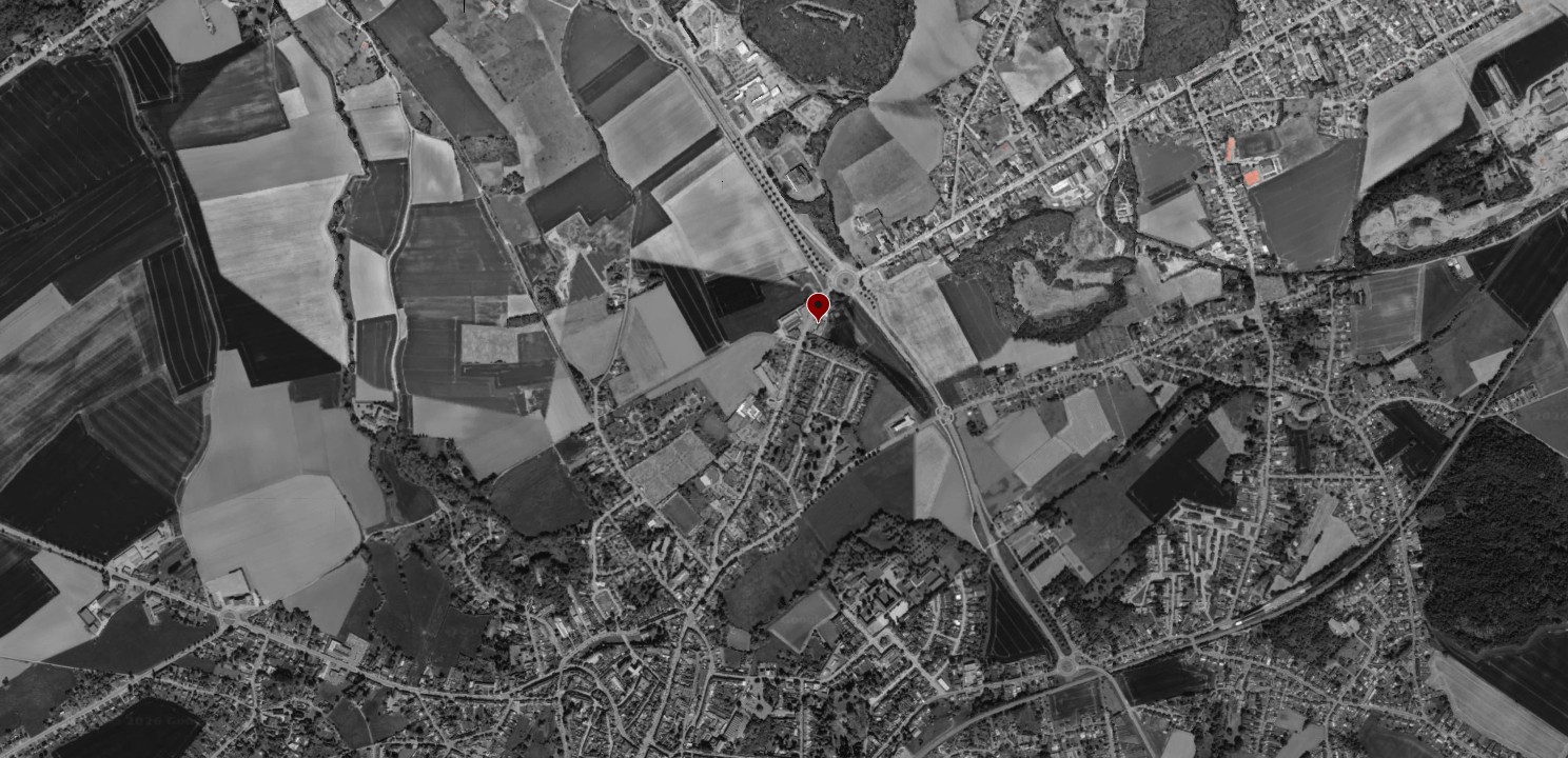 Vue aérienne en noir et blanc de Binche avec le repère rouge de l'implantation du projet