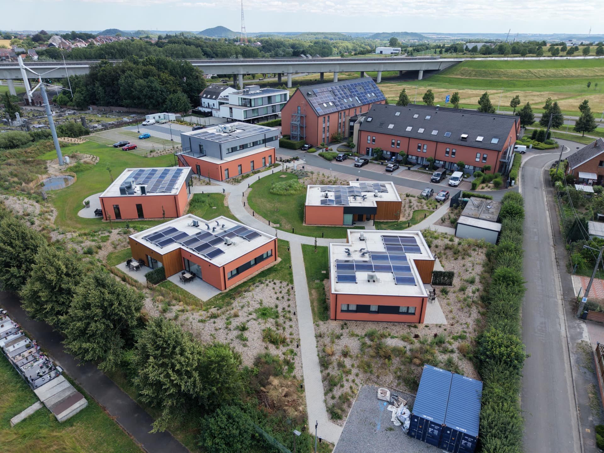 Vue aérienne d'un ensemble de bâtiments contemporains à façades terracotta avec panneaux solaires