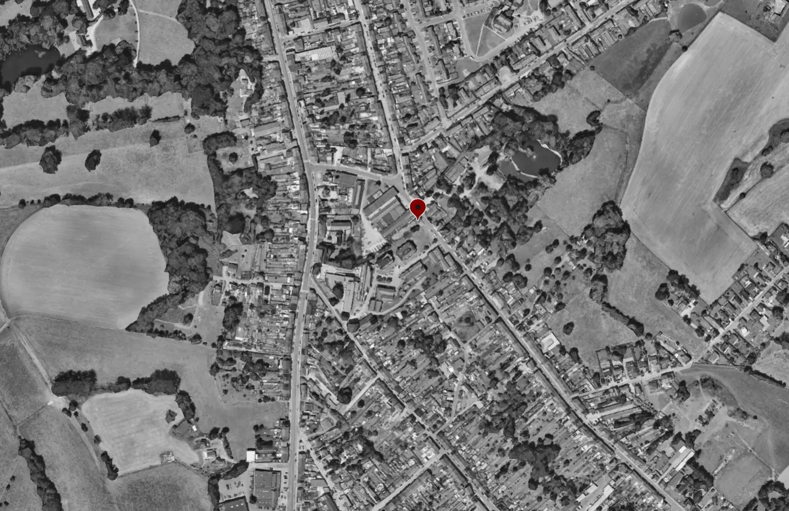 Vue aérienne en noir et blanc de Manage avec le repère rouge de l'implantation du projet