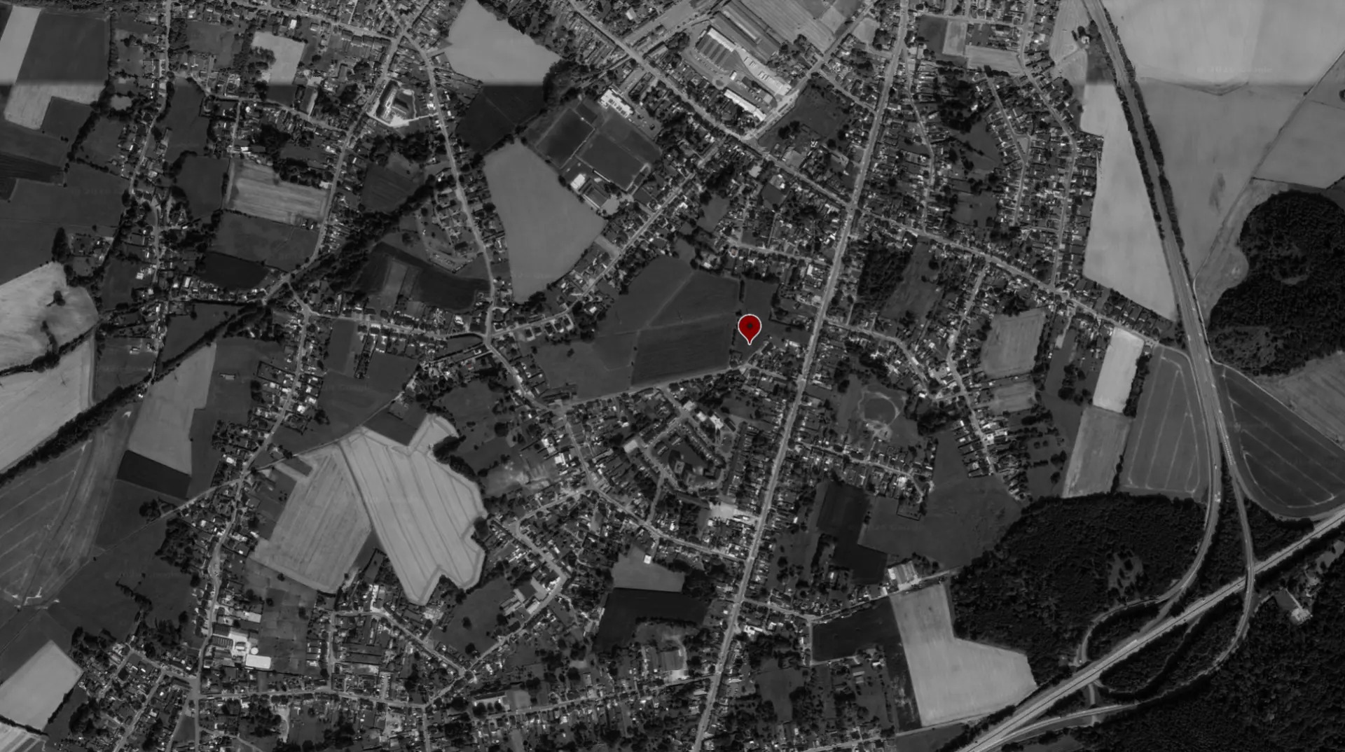 Vue aérienne en noir et blanc d'Anderlues avec le repère rouge de l'implantation du projet