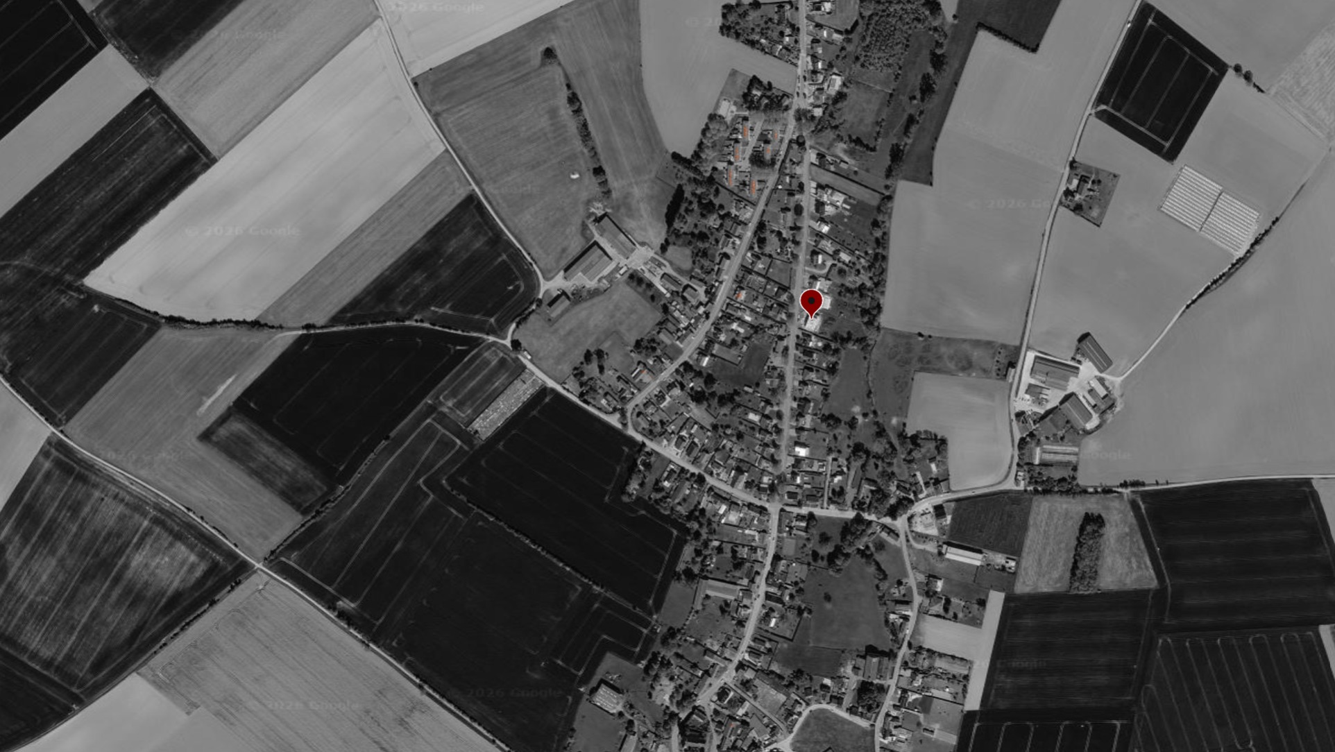 Vue aérienne en noir et blanc d'Estinnes avec le repère rouge de l'implantation du projet