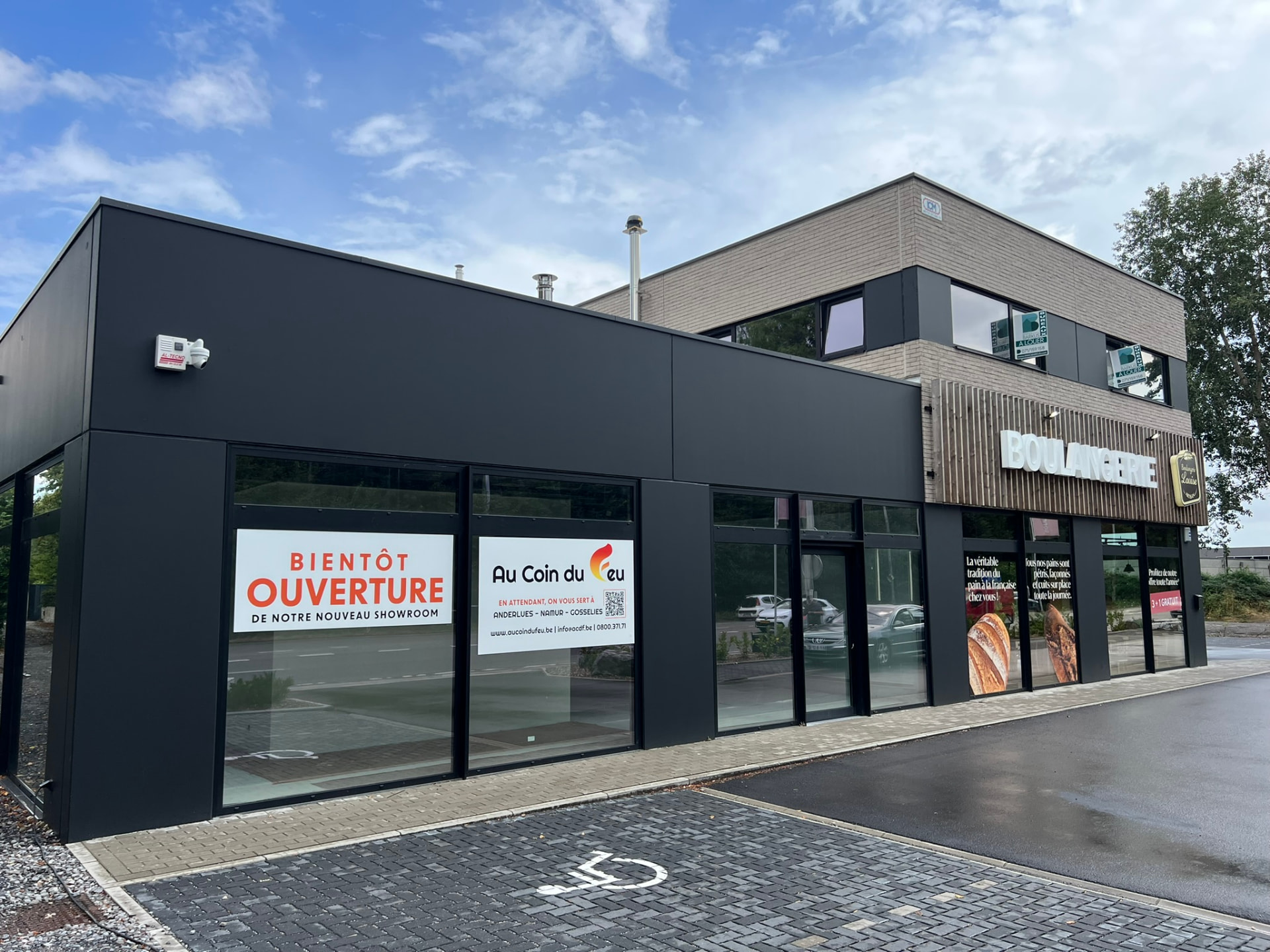 Vue latérale du showroom vitré et de la zone de parking