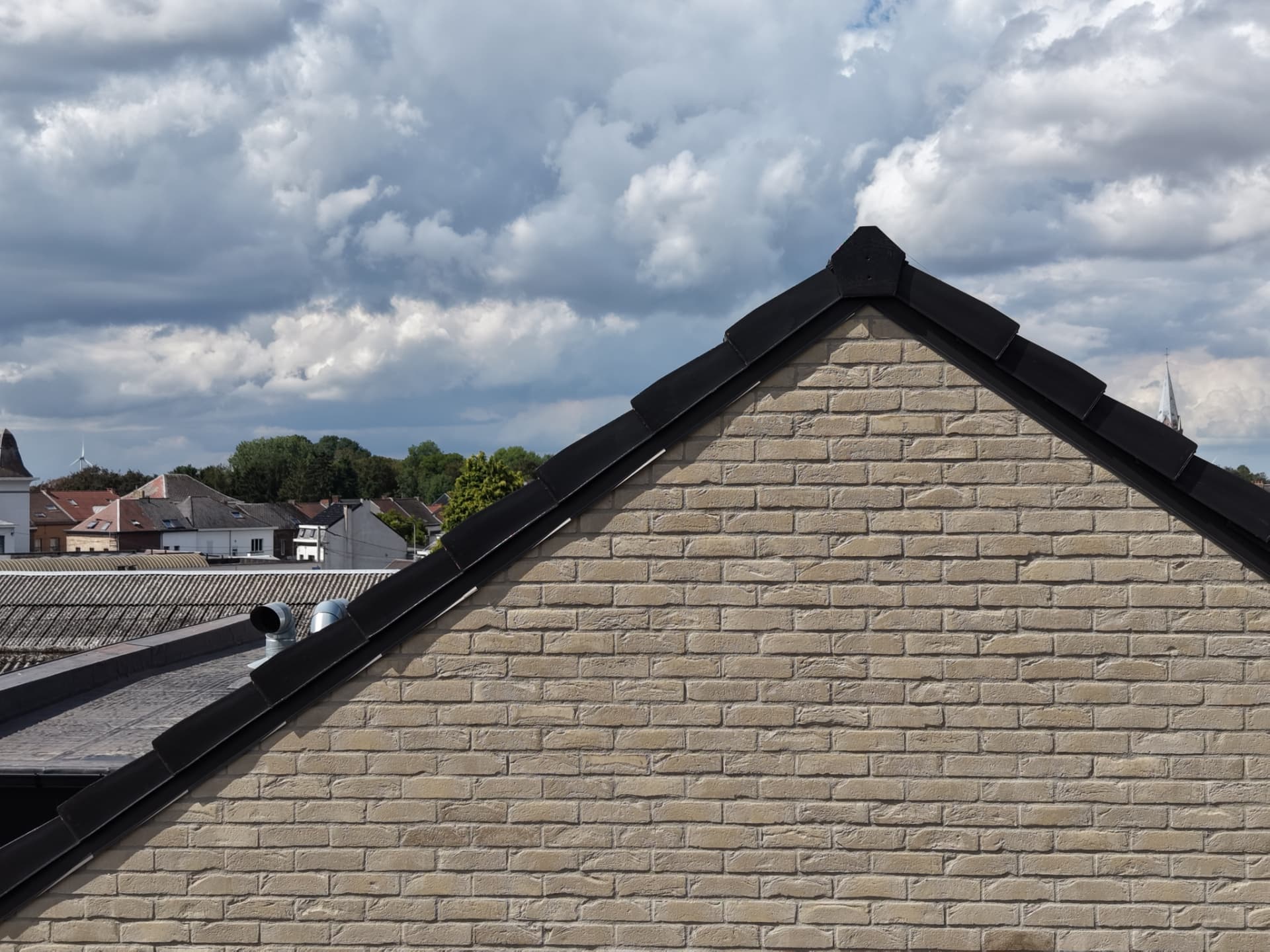 Détail du pignon en briques claires et de sa rive en zinc noir