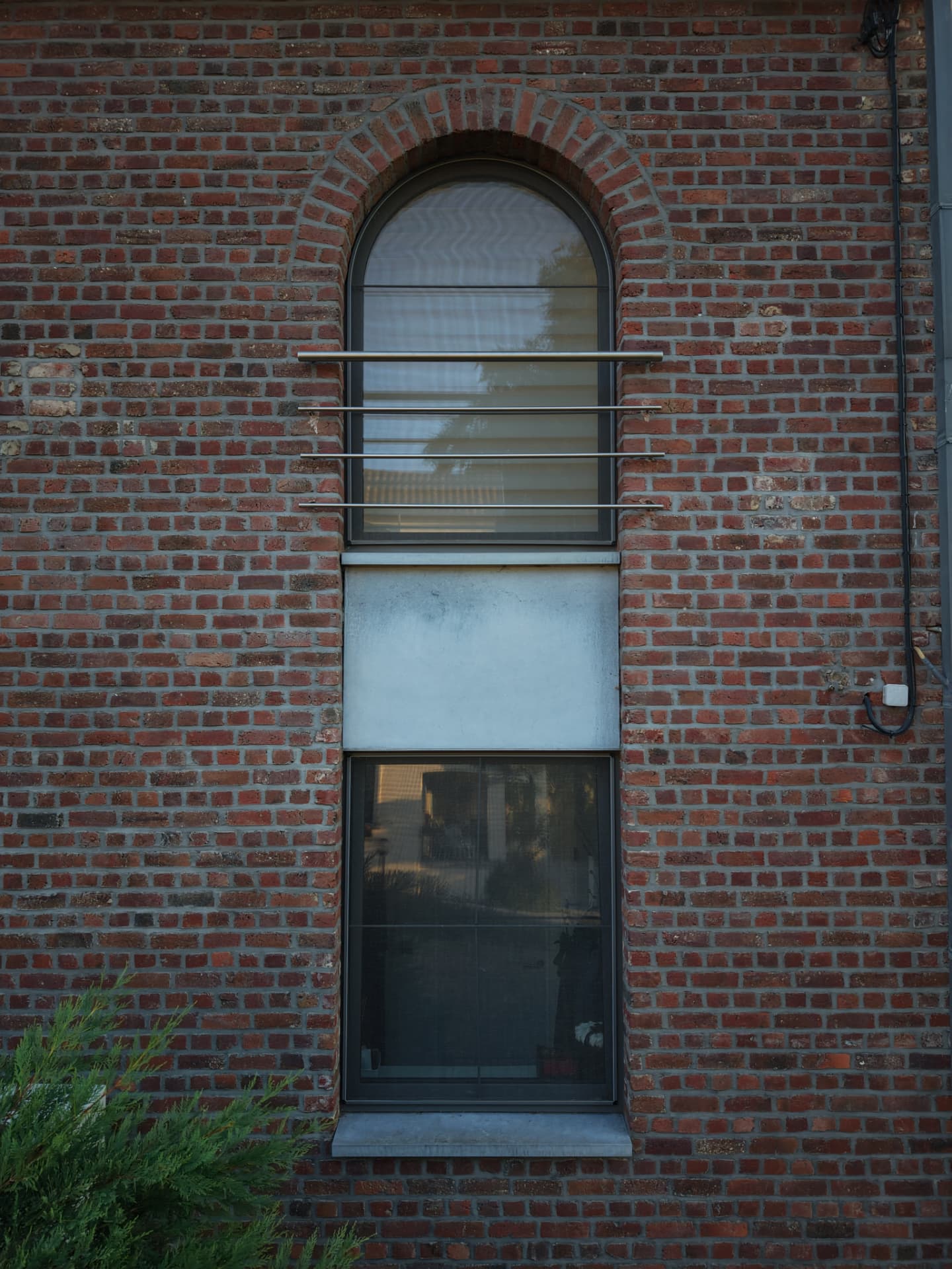 Composition verticale de deux fenêtres dans la façade en briques